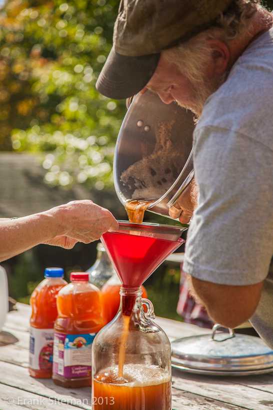 pouring fresh juice into a gallon jug